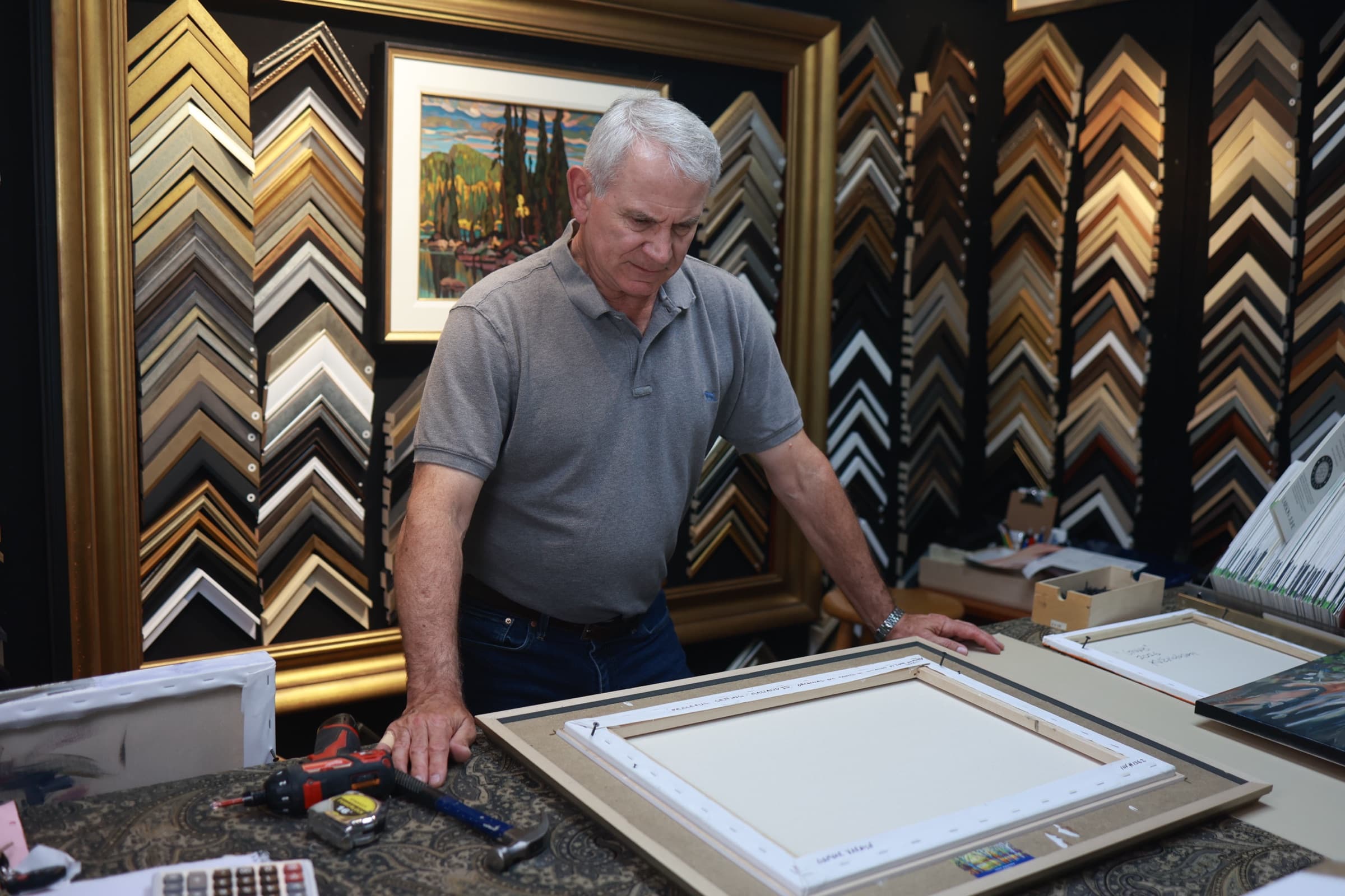Custom framer at the workbench in the Gallery 88 Arts framing shop