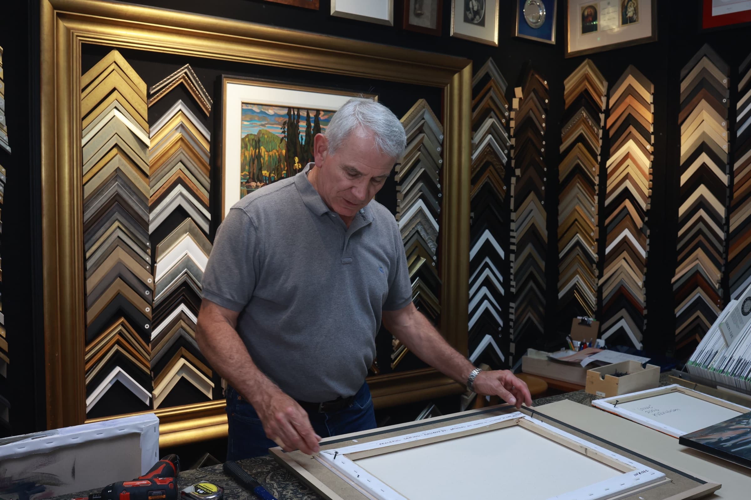 Custom framer at the workbench in the Gallery 88 Arts framing shop